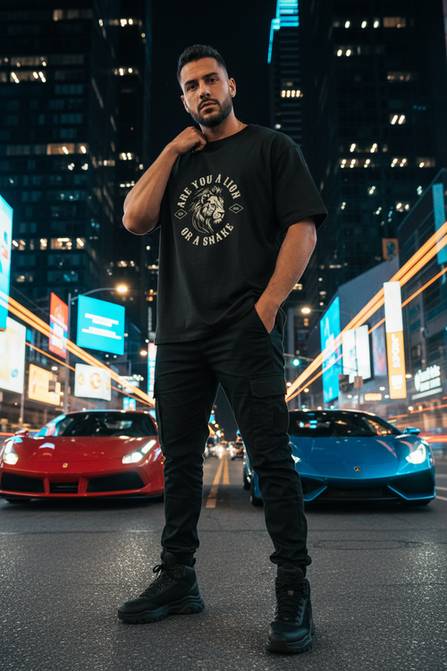 Hispanic male model wearing Are You a Lion or a Snake Graphic Tee in city night setting with sports cars